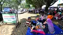 Sejumlah pengunjung beristirahat di area wisata Taman Mini Indonesia Indah, Jakarta, Minggu (19/07/2015). Makan bersama sambil menggelar tiker di tempat wisata menjadi pilihan warga yang mengunjungi tempat wisata TMII. (Liputan6.com/Yoppy Renato)