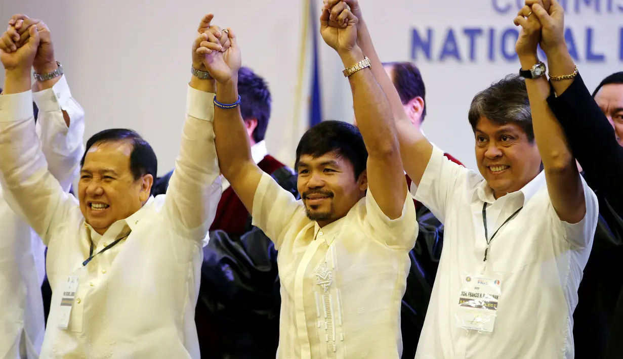 Manny Pacquiao bergandeng tangan bersama senator baru lainnya, Dick Gordon dan Kiko Pangilinan, Filipina, Kamis (19/5). Pacquiao berhasil menduduki 1 dari 12 kursi senator di Majelis Tinggi setelah mendapat 16 juta suara. (REUTERS/Erik De Castro)