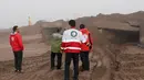 Petugas membantu orang-orang yang terjebak dalam lumpur setelah banjir di Provinsi Hormozgan di selatan Iran (4/1/2022). Otoritas meteorologi telah memperingatkan hari Minggu (2/1) akan hujan lebat dan banjir. (AFP/Iranian Red Crescent)