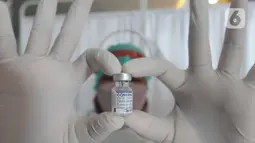 Tenaga kesehatan menunjukkan botol vaksin saat vaksinasi booster COVID-19 di RSUD Tangerang Selatan, Rabu (12/1/2022). Lebih dari 60 warga lanjut usia (lansia) Tangsel mendapatkan vaksinasi lanjutan (booster) COVID-19 dengan jenis Pfizer. (merdeka.com/Arie Basuki)