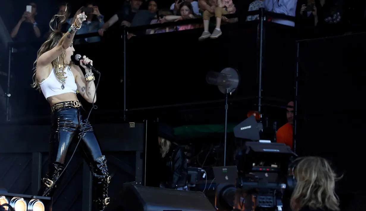 Aksi Miley Cyrus saat tampil pada hari terakhir Festival Glastonbury di Worthy Farm, Somerset, Inggris, Minggu (30/6/2019). Miley Cyrus tampil panas dengan gaya berapi-api saat menghibur ribuan penonton Festival Glastonbury. (Photo by Grant Pollard/Invision/AP)