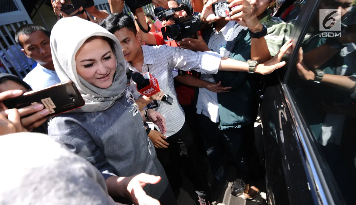 Istri Setya Novanto, Deisti Astriani Tagor menghindari kejaran pewarta usai mengunjungi SN di Rutan KPK, Jakarta, Senin (25/12). Sejumlah anggota keluarga Setya Novanto hadir menjenguk pada libur Hari Natal kali ini.  (Liputan6.com/Helmi Fithriansyah)