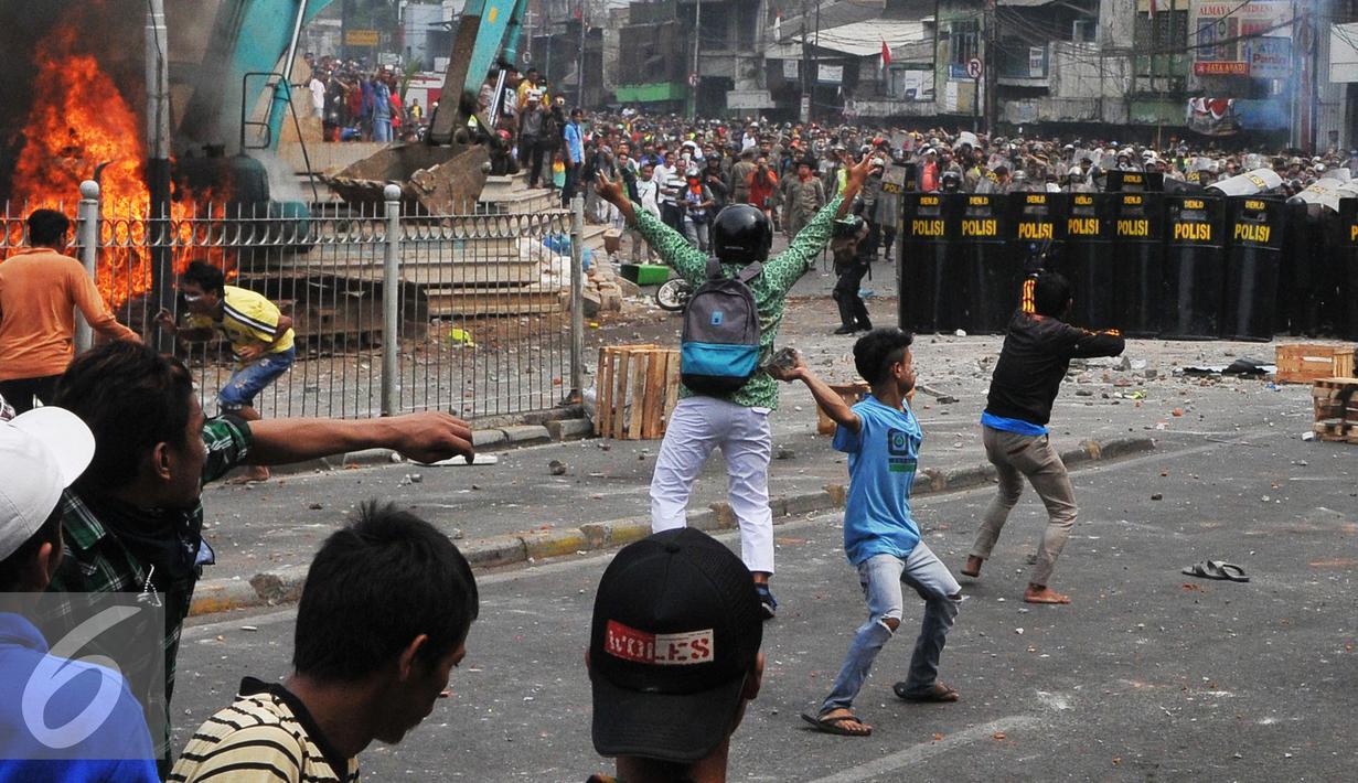 Massa menyerang Petugas kepolisian dan Satpol PP saat penggusuran Kampung Pulo, Jakarta, Kamis (20/8/2015). Penggusuran pemukiman Kampung Pulo dilakukan oleh 2.200 personel gabungan untuk normalisasi Sungai Ciliwung. (Liputan6.com/Herman Zakharia)