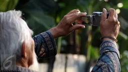 Warga menggunakan kamera digital untuk menyaksikan proses gerhana matahari di sekitar Taman Ismail Marzuki, Jakarta, Rabu (9/3/2016). Di Jakarta, fenomena gerhana matahari 90% bisa diamati selama 2,11 menit. (Liputan6.com/Helmi Fithriansyah)   