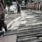 Anak anak melintasi jembatan dari kayu yang menjadi penghubung antara Jalan Karet Pasar Baru VII, Karet Tengsin dan Jalan Pam Baru, Bendungan Hilir, Tanah Abang, Rabu (30/1). (Liputan6.com/Faizal Fanani)