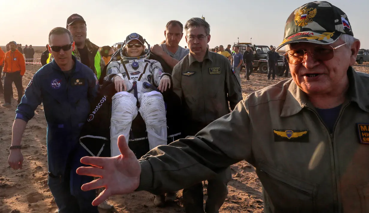 Petugas membawa astronaut AS, Peggy Annette Whitson setelah berhasil mendarat di daerah terpencil di luar kota Dzhezkazgan, Kazakhstan, Minggu (3/9). Whitson kembali ke bumi setelah melakukan misi selama 665 hari di ISS. (Sergei Ilnitsky/Pool via AP)