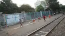 Anak-anak bermain sepak bola di pinggir rel kereta api di kawasan Kemayoran, Jakarta, Senin (24/7). Minimnya lahan bermain menyebabkan anak-anak terpaksa bermain di lokasi tersebut, meskipun berbahaya bagi keselamatan. (Liputan6.com/Immanuel Antonius)