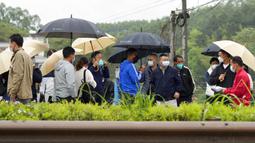 Kerabat penumpang pesawat China Eastern Airlines tiba dekat lokasi kecelakaan di Desa Lu, Provinsi Guangxi, China, Rabu (23/3/2022). Pencarian petunjuk tentang mengapa pesawat China Eastern Airlines jatuh ditangguhkan karena hujan. (AP Photo/Ng Han Guan)
