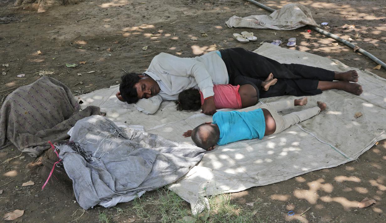 Keluarga tidur di bawah pohon selama musim panas di New Delhi, India (10/6/2019). Kondisi gelombang panas yang parah menyapu bagian utara dan barat India dengan suhu maksimum melonjak hingga 48 derajat Celcius ( 118 F) di beberapa bagian Rajasthan. (AP Photo/Manish Swarup)