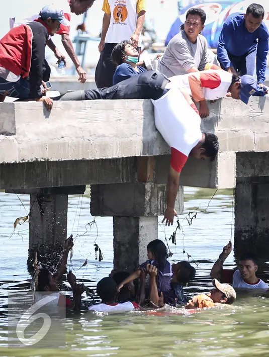 Warga berusaha menolong seorang anak kecil yang terjatuh ke laut di dermaga Muara Angke, Jakarta, Kamis (24/3). Akibat kelalaian ibunya seorang anak tercebur ke laut dan langsung di selamatkan warga dan prajurit TNI AL. (Liputan6.com/Faizal Fanani)