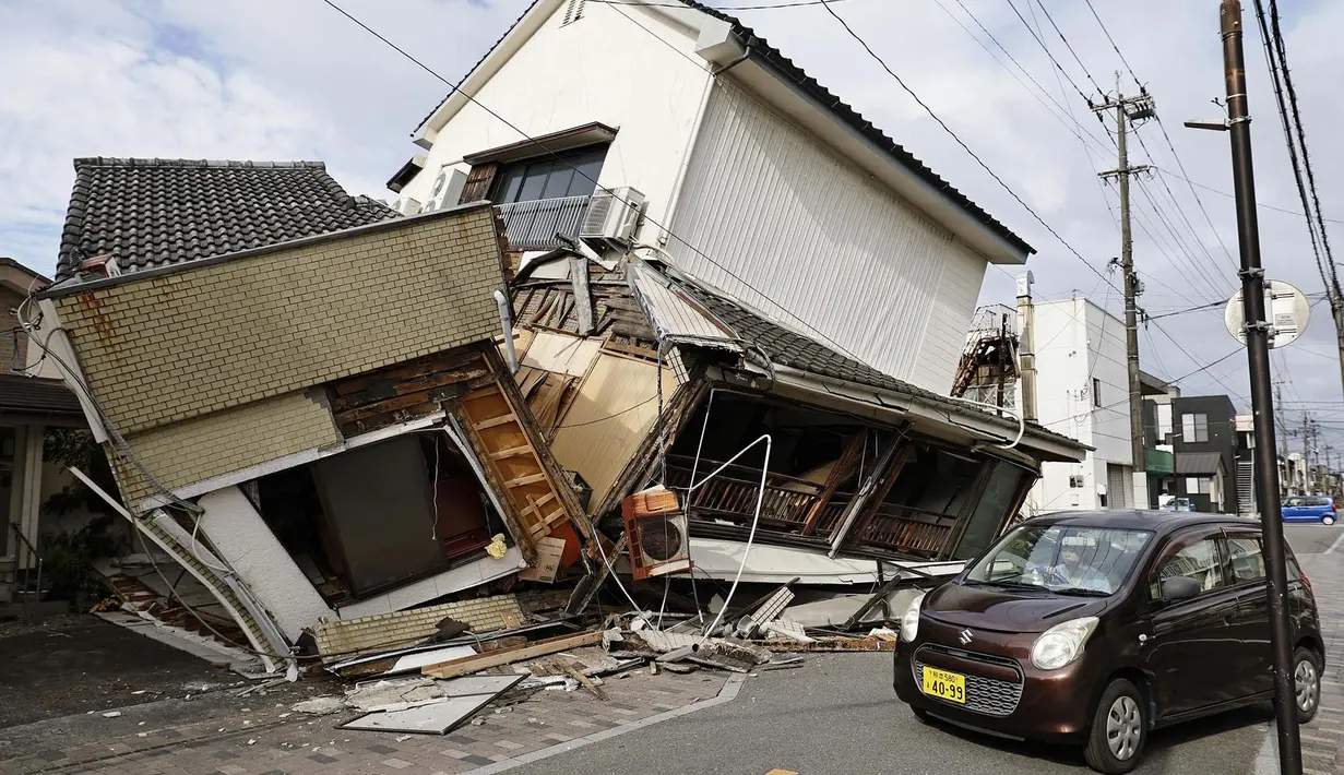 Sebuah kendaraan melintas di dekat rumah-rumah yang runtuh setelah gempa bumi di Yatsushiro, Prefektur Kumamoto, Rabu, 29 Juli 2026. (Juntaro Yokoyama/Kyodo News via AP)