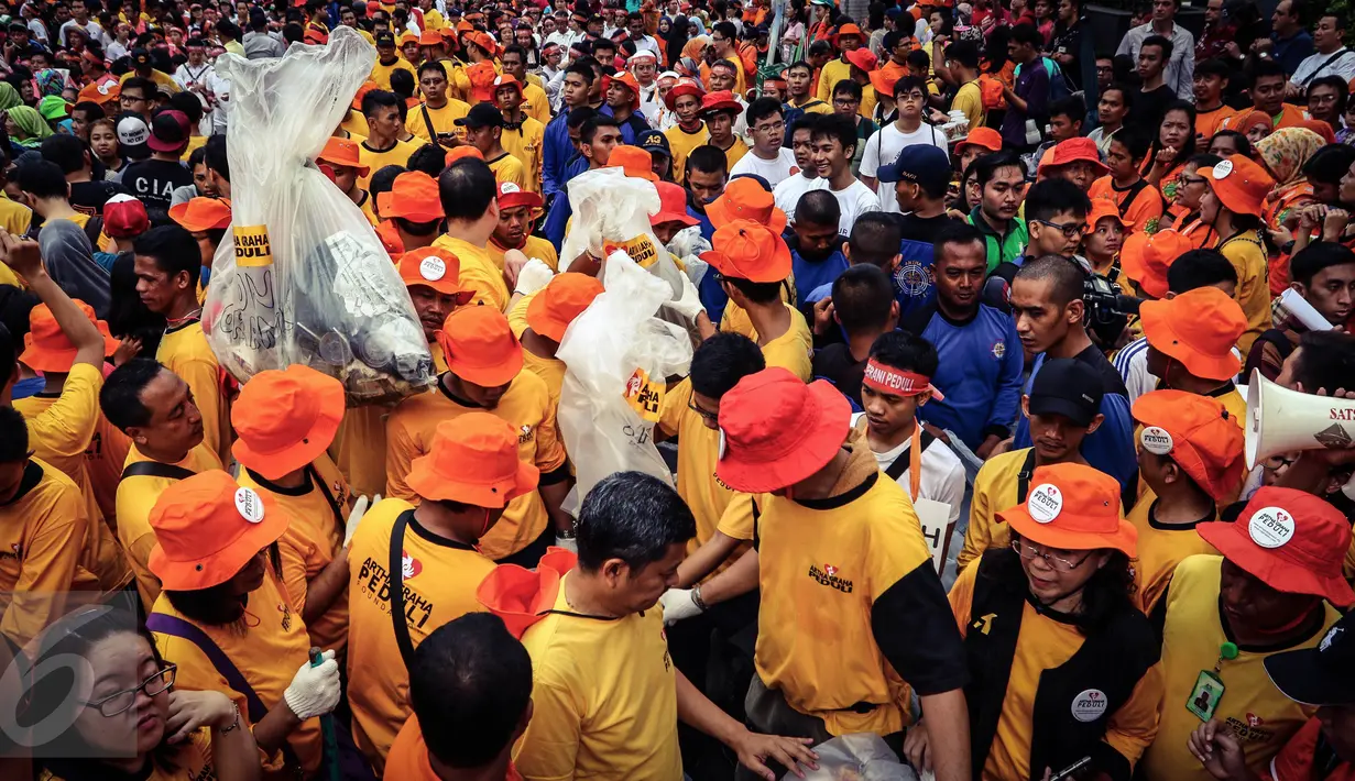 Ratusan karyawan dan relawan Artha Graha Peduli mengangkat kantong sampahdi kawasan Bundaran HI, Jakarta, (21/02). 1500 orang dari berbagai komunitas, instansi dan perusahaan mereka membersihkan sampah dalam rangka HPSN 2016. (Liputan6.com/Fery Pradolo)