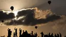 Pengunjung menyaksikan Festival Balon Udara Gilboa di dekat Kibbutz Ein Harod, Lembah Jizreel, Israel (4/8). Acara ini juga dimeriahkan dengan pertunjukan paragliders, paramotor dan karya para seniman udara. (AFP Photo/Manahem Kahana)