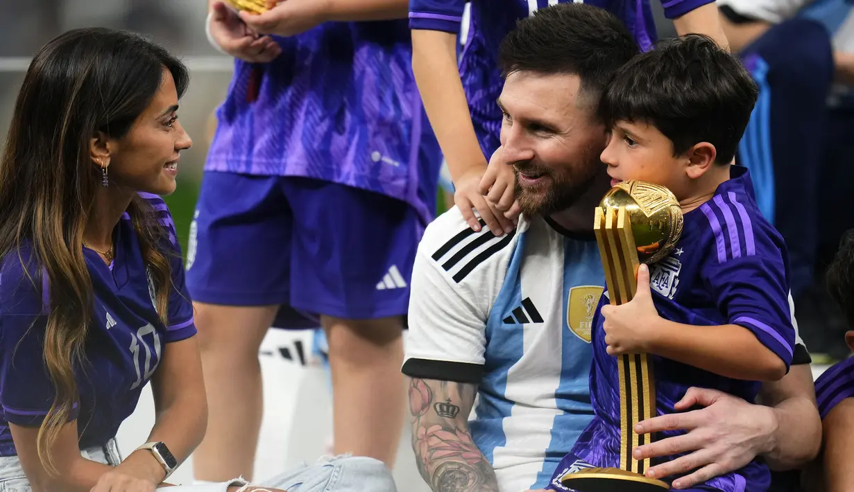 Pemain Argentina, Lionel Messi merayakan kemenangan timnya di Piala Dunia 2022 bersama keluarganya setelah mengalahkan Prancis pada laga final yang berlangsung di Lusail Stadium, Qatar, Minggu (18/12/2022). Albiceleste menang 4-2 atas Prancis di babak penalti. (AP Photo/Manu Fernandez)
