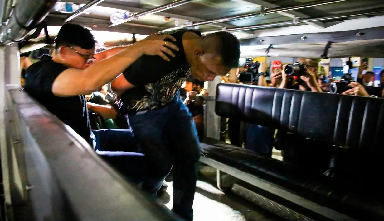 Pelaku penyenderaan Alchie Paray dimasukkan ke dalam mobil polisi usai ditangkap di V-Mall, Manila, Filipina, Senin (2/3/2020). Belum diketahui apakah ada sandera yang terluka atau tidak. (AP Photo/Gerard Carreon)