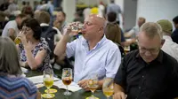 Seorang pria menikmati minum bir selama The Great British Beer Festival di Kensington Olympia di London barat (6/8/2019). Great British Beer Festival tahunan ini diadakan 6-10 Agustus 2019. (AFP Photo/Tolga Akmen)