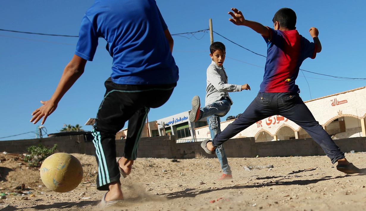 Sejumlah anak Palestina bermain sepak bola di kawasan Gaza, Jumat (3/11/2017). Sepak bola tidak hanya menjadi olahraga favorit, tapi juga sebagai salah satu cara bagi warga untuk mengurangi ketegangan akibat peperangan. (AFP/Mohammed Abed)