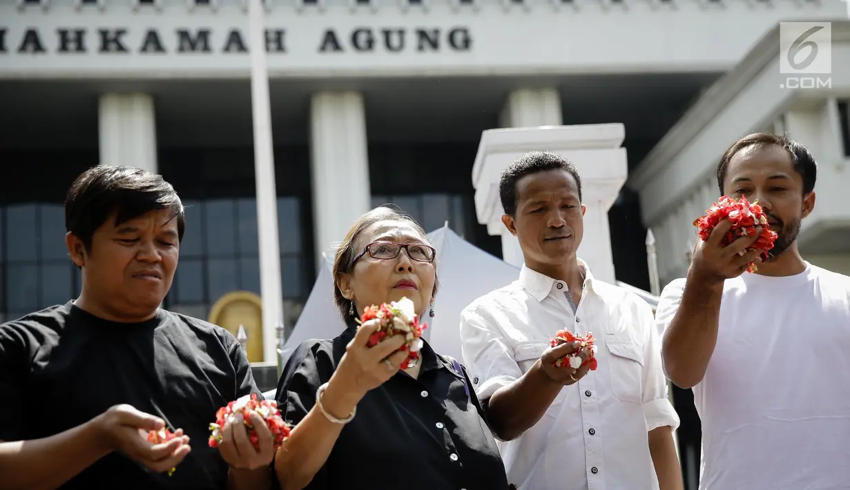 Sejumlah massa saat menggelar aksi damai di depan Mahkamah Agung, Jakarta, Rabu (7/6). Dalam aksinya mereka menaburkan bungan pada payung sebagai bentuk simbol kekhawatiran matinya keadilan dan penegakan hukum. (Liputan6.com/Faizal Fanani)