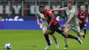 Pemain AC Milan Rafael Leao (kiri) berebut bola dengan pemain Genoa Morten Frendrup pada pertandingan Serie A di Stadion San Siro, Milan, Italia, 15 April 2022. AC Milan menang 2-0. (AP Photo/Luca Bruno)