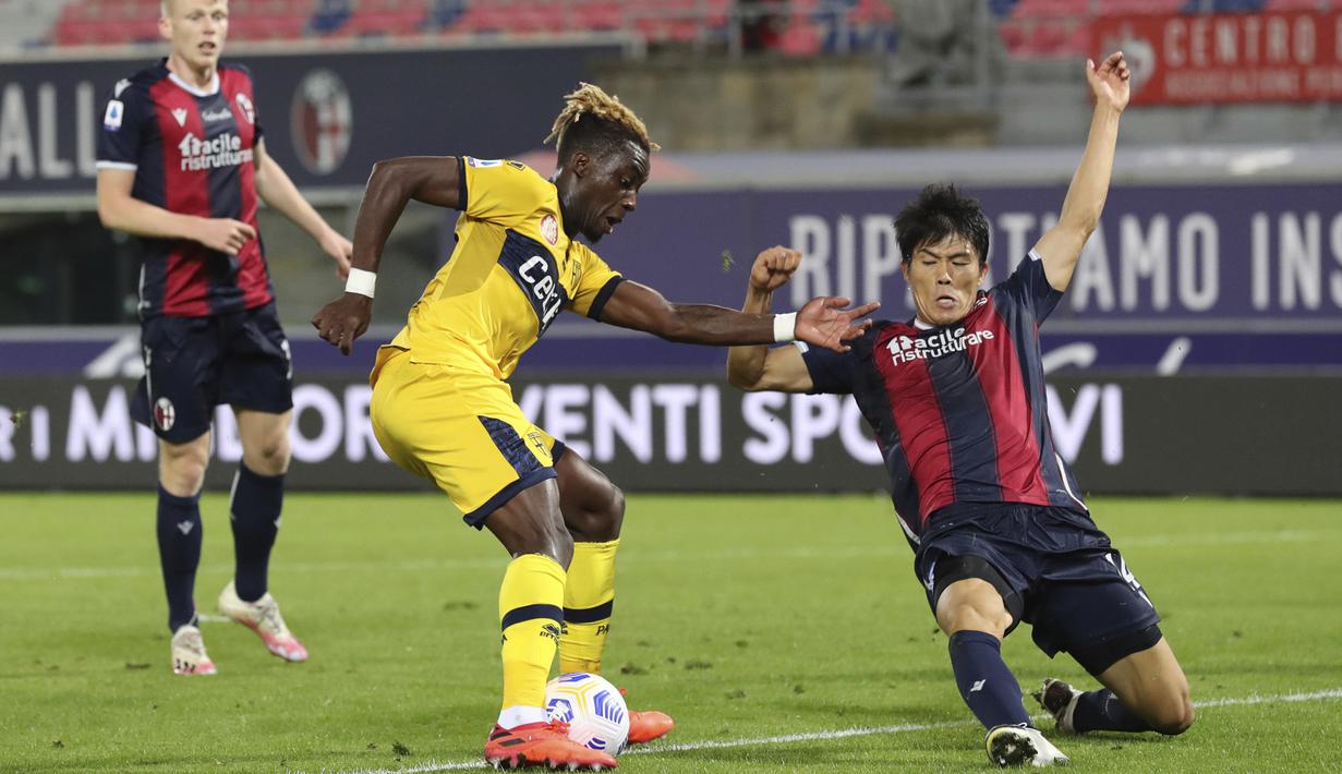 Bek Bologna, Takehiro Tomiyasu, berebut bola dengan penyerang Parma, Yann Karamoh, pada laga lanjutan Liga Italia di di Stadion Renato Dell'Ara, Selasa (29/9/2020) dini hari WIB. Bolongna menang 4-1 atas Parma. (Filippo Rubin/LaPresse via AP)