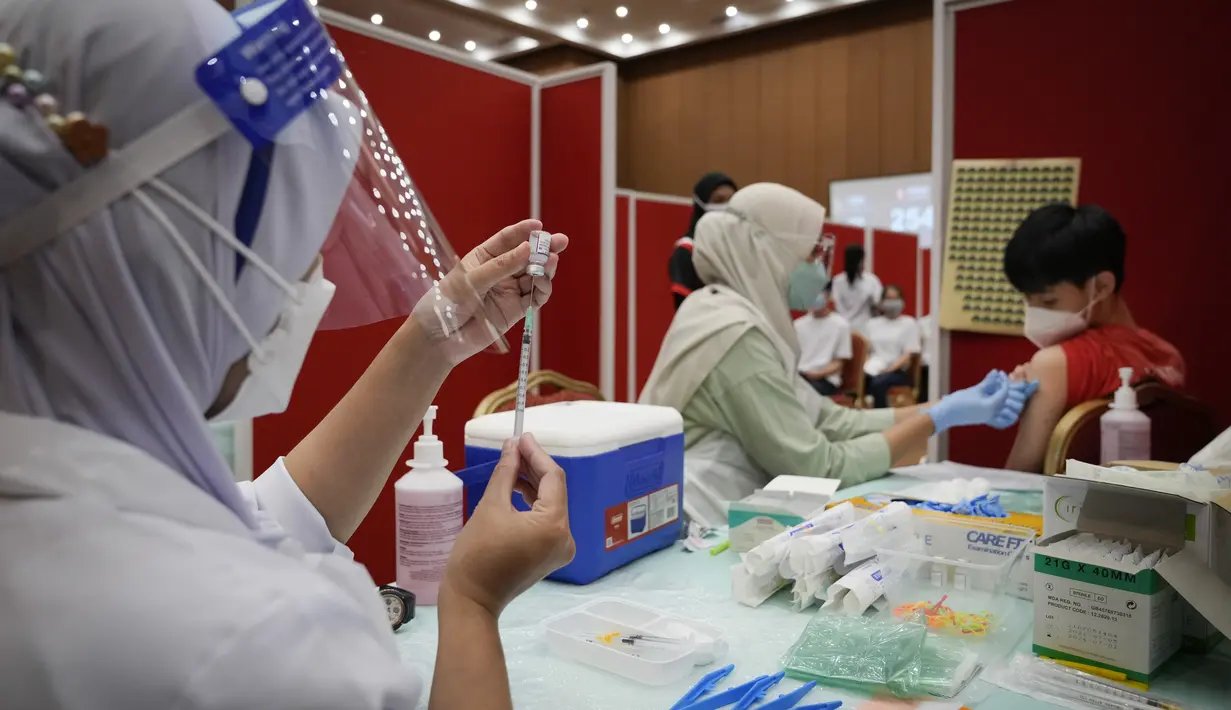 Seorang siswa sekolah menengah menerima dosis vaksin Pfizer terhadap penyakit coronavirus (COVID-19) di pusat vaksin di Shah Alam, Malaysia, Senin (20/9/2021). (AP Photo/Vincent Thian)