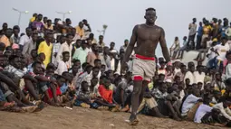 Seorang pegulat mendekati arena saat kompetisi gulat tradisional Nuba antara tim dari daerah Haj Youssef dan Omdurman di Ibu Kota Khartoum, Sudan, 30 Juli 2021. (Abdulmonam EASSA/AFP)