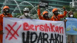 Aktivis membentangkan spanduk saat kampanye damai terkait buruknya udara Jakarta di Bundaran HI, Rabu (5/12). Dalam aksinya, mereka mengimbau kepada warga sekitar untuk sadar dan berpartisipasi memperbaiki kualitas udara Jakarta. (Merdeka.com/Imam Buhori)