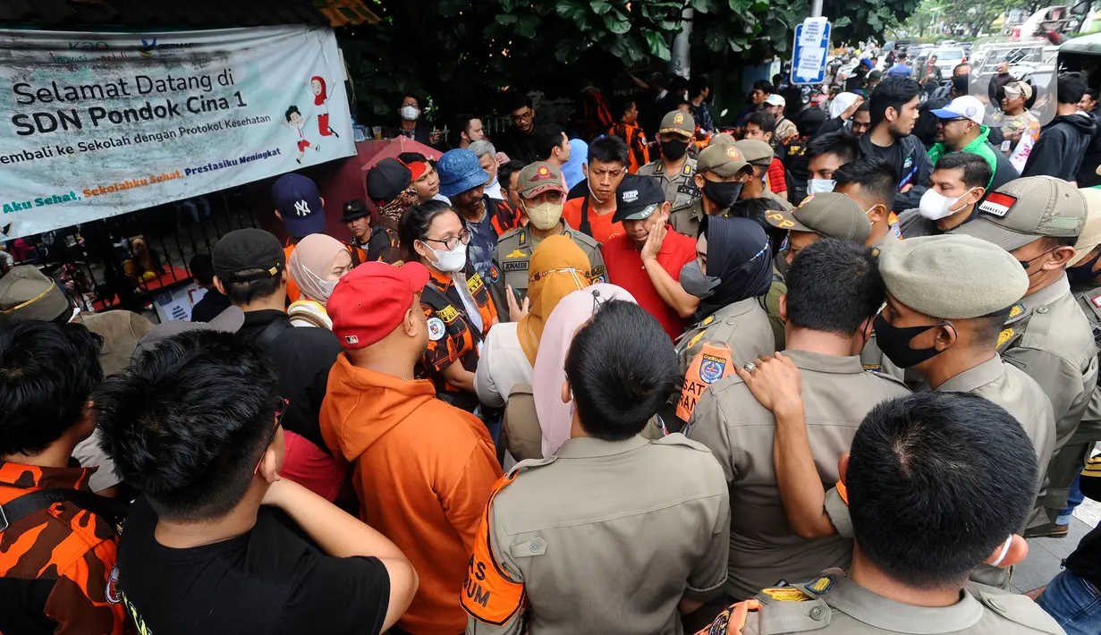 Orangtua murid menghadang pasukan Satpol PP yang hendak mengosongkan bangunan SDN Pondok Cina 1, Depok, Jawa Barat, Minggu (11/12/2022). Ketegangan dan adu argumentasi antara petugas dan sejumlah orang yang mengaku sebagai kuasa hukum orang tua siswa pun tak terhindarkan. (merdeka.com/Arie Basuki)