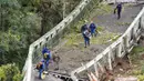 Jembatan Gantung Ambruk: Tim penyelamat berjalan di atas jembatan gantung yang ambruk di atas sungai Tarm, Prancis, (18/11/2019). Jembatan  yang menghubungkan kota Mirepoix-sur-Tarn itu tiba-tiba ambruk hingga menyebabkan seorang gadis berusia 15 tahun dan satu sopir truk tewas. (ERIC CABANIS/AFP)