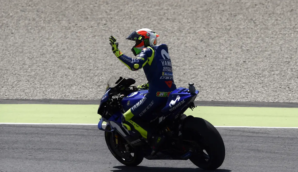Pembalap Italia Movistar Yamaha, Valentino Rossi menyapa penonton setelah memenangkan balapan di posisi ketiga Moto Grand Prix di Sirkuit Mugello, Italia, Minggu (03/6). (AFP FOTO / Filippo Monteforte)