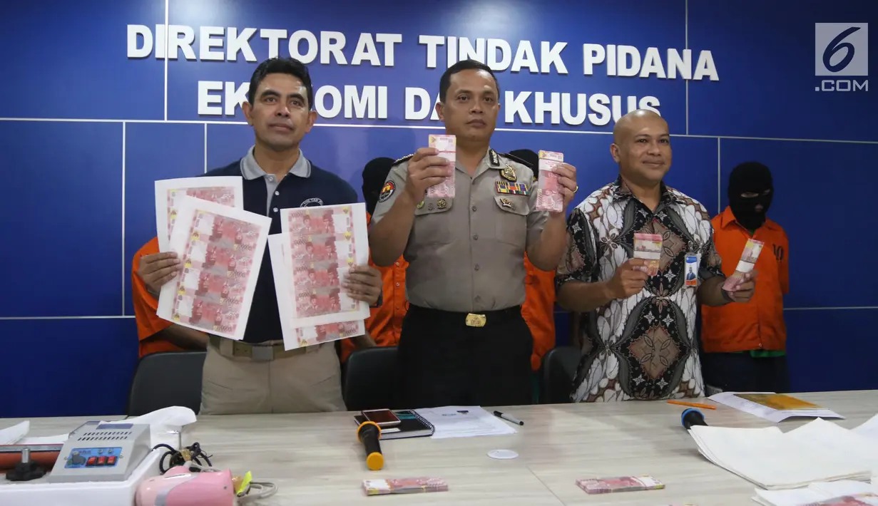 Analis Kebijakan Humas Polri Kombes Pol Sulistyo Pudjo (tengah) bersama Kadiv Penanggulangan Uang Palsu Bank Indonesia, Asral Mashuri (kanan) menunjukkan barang bukti uang palsu saat rilis di Jakarta, Jumat (16/3). (Liputan6.com/Arya Manggala)