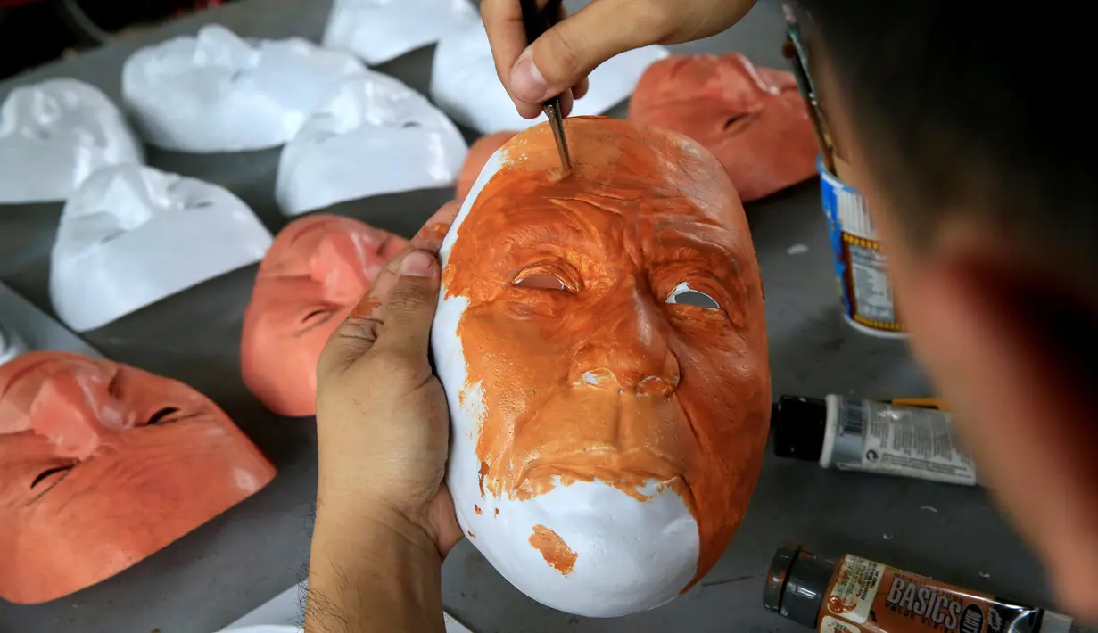 Mahasiswa seni rupa mengecat topeng Presiden Rodrigo Duterte untuk perayaan Halloween di Universitas Filipina, Kota Quezon, Filipina (13/10). Duterte juga pernah menghina Presiden AS Barack Obama. (REUTERS/Romeo Ranoco)