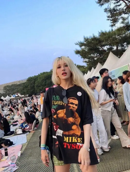 Santai tapi tetap kece, Somi terlihat memadukan oversized t-shirt dengan cetakan grafis penuh warna, plaid short pants warna hijau. (Instagram/somsomi0309).