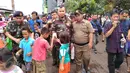 Sejumlah anak berebut mencium tangan dan bersalaman dengan musisi Ahmad Dhani saat tiba di  lokalisasi Kalijodo, Penjaringan, Jakarta, Senin (15/2). Suami dari Mulan Jameela itu mendatangi Kalijodo dikawal Banser Nahdlatul Ulama (NU). (Foto : Muslim AR)