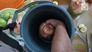 Suami NY, perempuan yang sedang melakukan isolasi mandiri karena terjangkit COVID-19, memasukkan kelapa ke dalam ember untuk diberikan kepada sang istri di kediamannya, Rabu (10/2/2021). (Liputan6.com/Herman Zakharia)