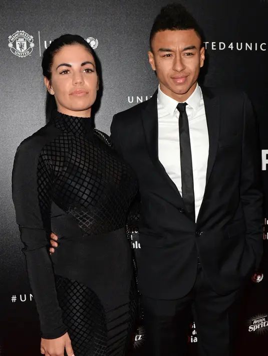 Gelandang Manchester United, Jesse Lingard (kanan) dan pacarnya Emma Hyde berpose di atas karpet merah saat mereka tiba untuk menghadiri "Inggris untuk UNICEF Gala Dinner" di Old Trafford, Manchester, Inggris, (29/11). (AFP PHOTO/OLI SCARFF)