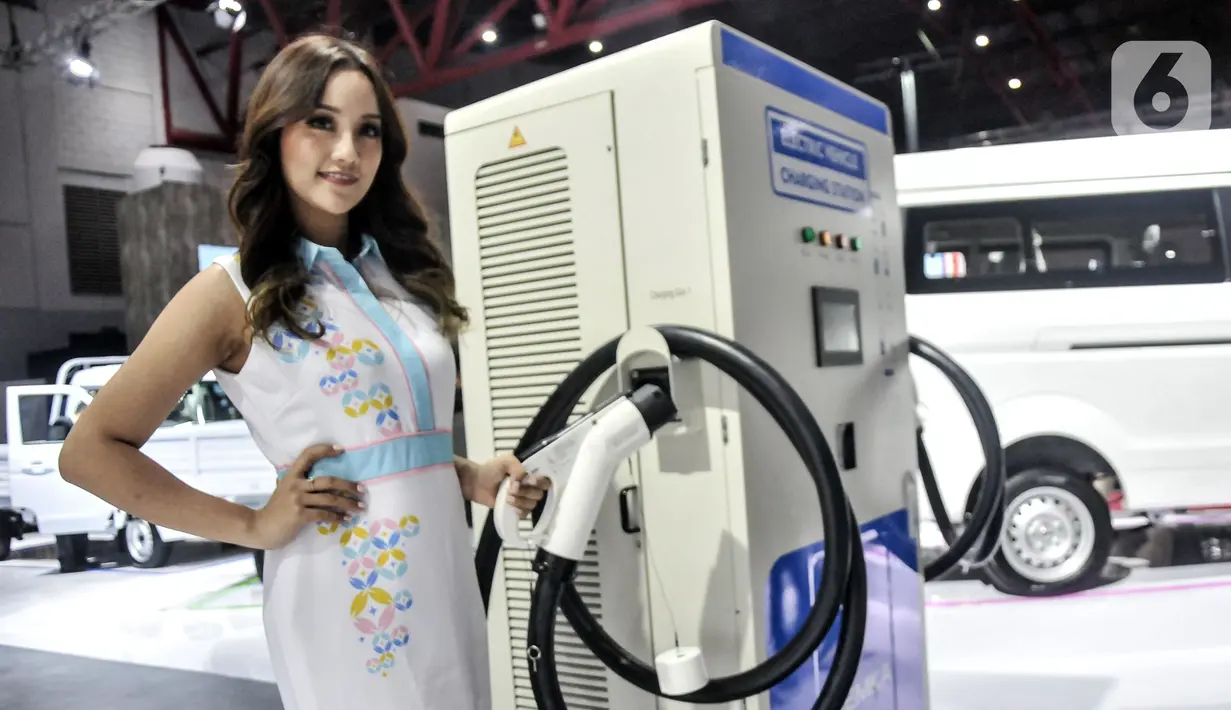 Sales promotion girl (SPG) berpose dekat alat pengisi daya mobil listrik dipamerkan pada Indonesia International Motor Show (IIMS) 2023 di Jiexpo Kemayoran, Jakarta, Kamis (16/2/2023). Selain mobil keluaran terbaru, pesona SPG cantik menjadi sorotan pengunjung sekaligus pemanis dalam pameran IIMS 2023. (merdeka.com/Iqbal S. Nugroho)