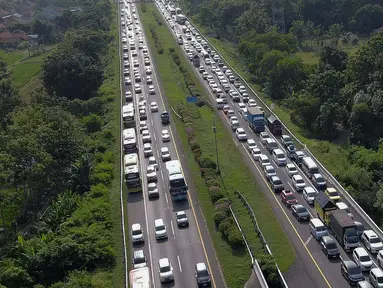 Foto udara memperlihatkan antrean kendaraan pemudik yang mengurangi laju kendaraannya saat melintasi jalan tol Palimanan-Kanci (Palikanci) KM 192, Cirebon, Jawa Barat, Minggu (7/4/2024). (Liputan6.com/Herman Zakharia)