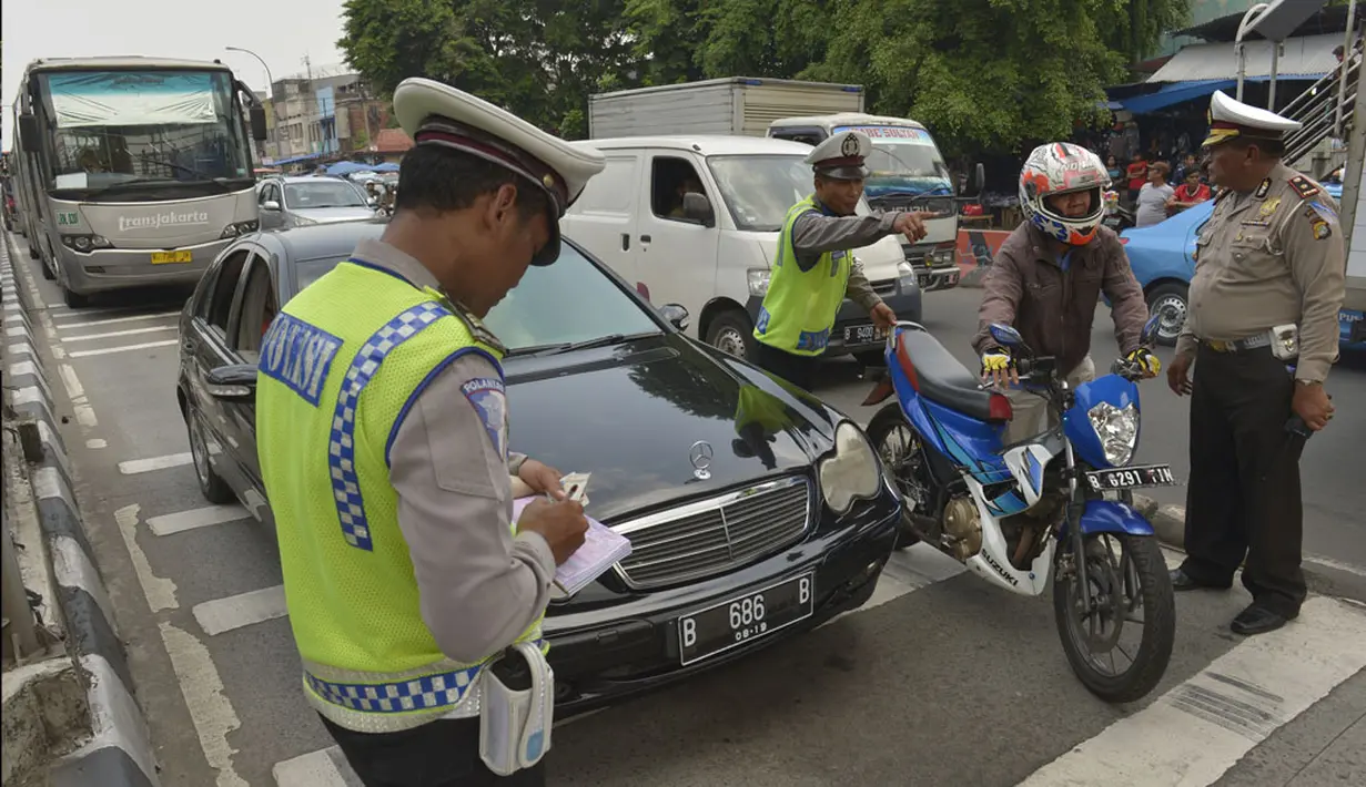 Polisi menilang pengendara kendaraan yang melewati jalur transjakarta ketika digelar Operasi Zebra 2014 di sekitar Pasar Senen, Jakarta, Rabu (26/11). Operasi tersebut menindak pengendara kendaraan yang melanggar aturan. (ANTARA FOTO/Saptono)