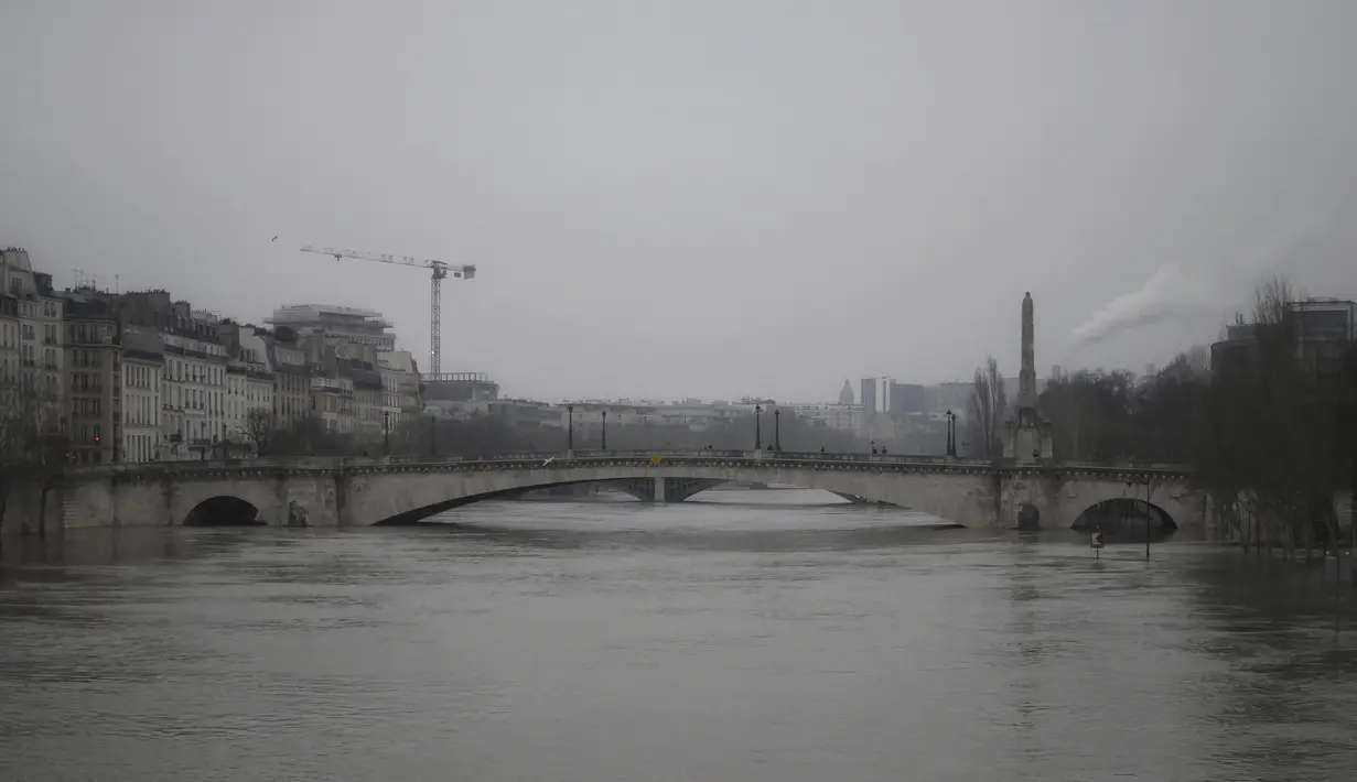 Tepian sungai Seine yang banjir di Paris, Senin (8/2/2021).  Jalanan Paris dibanjiri air luapan Sungai Seine hari ini setelah banjir di seluruh Eropa menyebabkan sungai meluap. (AP Photo/Thibault Camus)