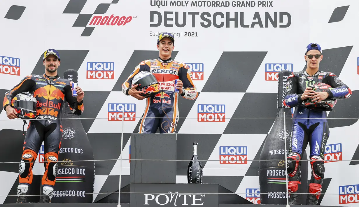Juara pertama Marc Marquez (tengah), juara kedua Miguel Oliveira (kiri), dan juara ketiga Fabio Quartararo (kanan) berdiri di podium balapan MotoGP di Sirkuit Sachsenring, Hohenstein-Ernstthal, Jerman, Minggu (20/6/2021). (Jan Woitas/dpa via AP)
