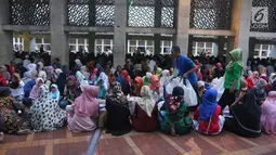 Panitia membagikan paket makanan kepada jemaah wanita yang ingin buka puasa di Masjid Istiqlal, Jakarta, Kamis (17/5). Mereka yang buka puasa di Masjid Istiqlal biasanya adalah tuna wisma, musafir, dan kaum duafa. (Liputan6.com/Arya Manggala)
