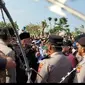 Pimpinan Ponpes Al-Zaytun Panji Gumilang mendekat ke kawat berduri yang dipasang polisi saat pondok pesantren tersebut didemo massa. (Liputan6.com/ Dok Ist)