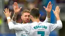 Pemain Real Madrid, Cristiano Ronaldo (kanan) menghampiri Sergio Ramos usai mencetak gol ke gawang Eibar pada laga La Liga di Stadion Ipurua, Eibar. Sabtu (10/3). Real Madrid melumat Eibar dengan skor 2-1. (ANDER GILLENEA/AFP)