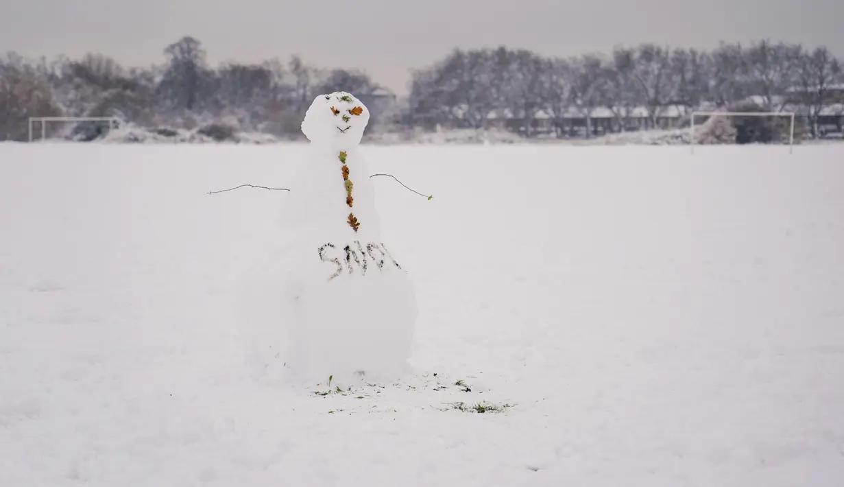 Manusia salju digambarkan di Wanstead Flats, di London, Senin (10/12/2022). Salju dan es telah menyapu sebagian Inggris, dengan suhu dingin dan kabut yang membekukan serta salju diperkirakan akan tetap ada sepanjang minggu ini. (AP Photo/Alberto Pezzali)