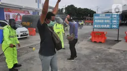 Calon penumpang disemprot disinfektan saat sterilisasi puluhan angkutan bus yang masuk di Terminal Bawen, Jumat (27/3/2020).  Sterilisasi dilakukan dengan menyemprotkan cairan disinfektan ke armada dan para penumpang yang turun di terminal tersebut. (Liputan6.com/Gholib)
