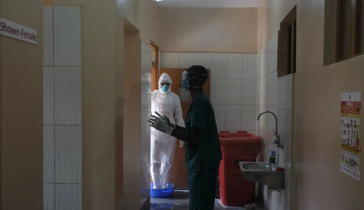 Dokter mendisinfeksi diri mereka sendiri setelah mengunjungi pasien yang kontak dengan korban Ebola, di bagian isolasi Rumah Sakit Rujukan Regional Entebbe di Entebbe, Uganda Kamis, 20 Oktober 2022. Pejabat WHO mengatakan pada Kamis (20/10), Wabah Ebola di Uganda berkembang pesat dalam sebulan yang membuat situasi yang sulit bagi petugas kesehatan di lapangan. (AP Photo/Hajarah Nalwadda)