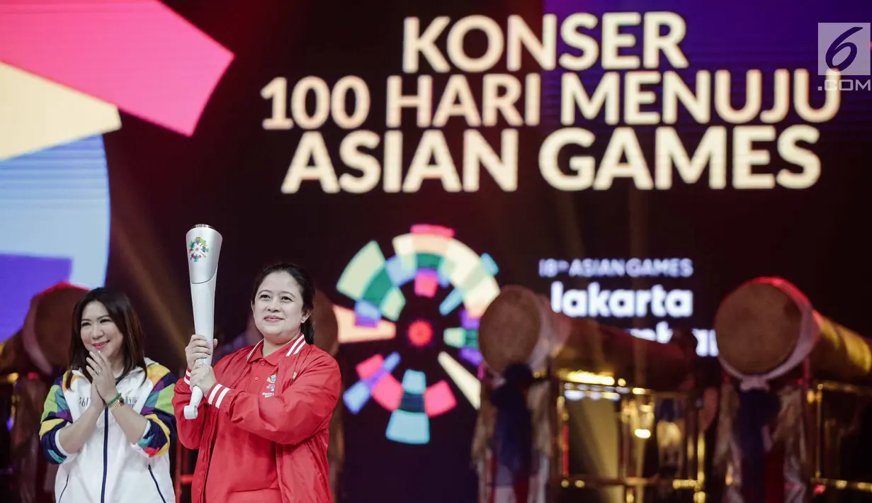 Menko PMK Puan Maharani disaksikan Susi Susanti memegang obor untuk Asian Games 2018 saat peluncuran Torch Asian Games dalam konser 100 Hari Menuju Asian Games 2018 di Studio 6 Emtek, Jakarta, Kamis (10/5). (Liputan6.com/Faizal Fanani)