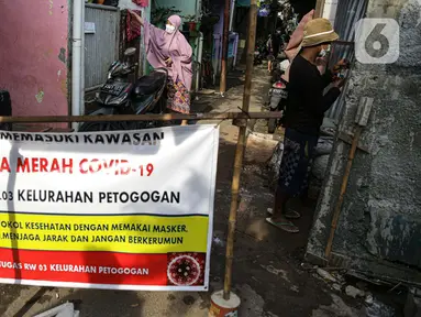 Spanduk menutup akses masuk zona merah COVID-19 di Kelurahan Petogogan RT 006 RW 003, Jakarta, Selasa (22/6/2021). Pemerintah Provinsi DKI Jakarta memperbarui data zona pengendalian virus Corona di tingkat rukun tetangga (RT) se-Ibu Kota.  (Liputan6.com/Faizal Fanani)