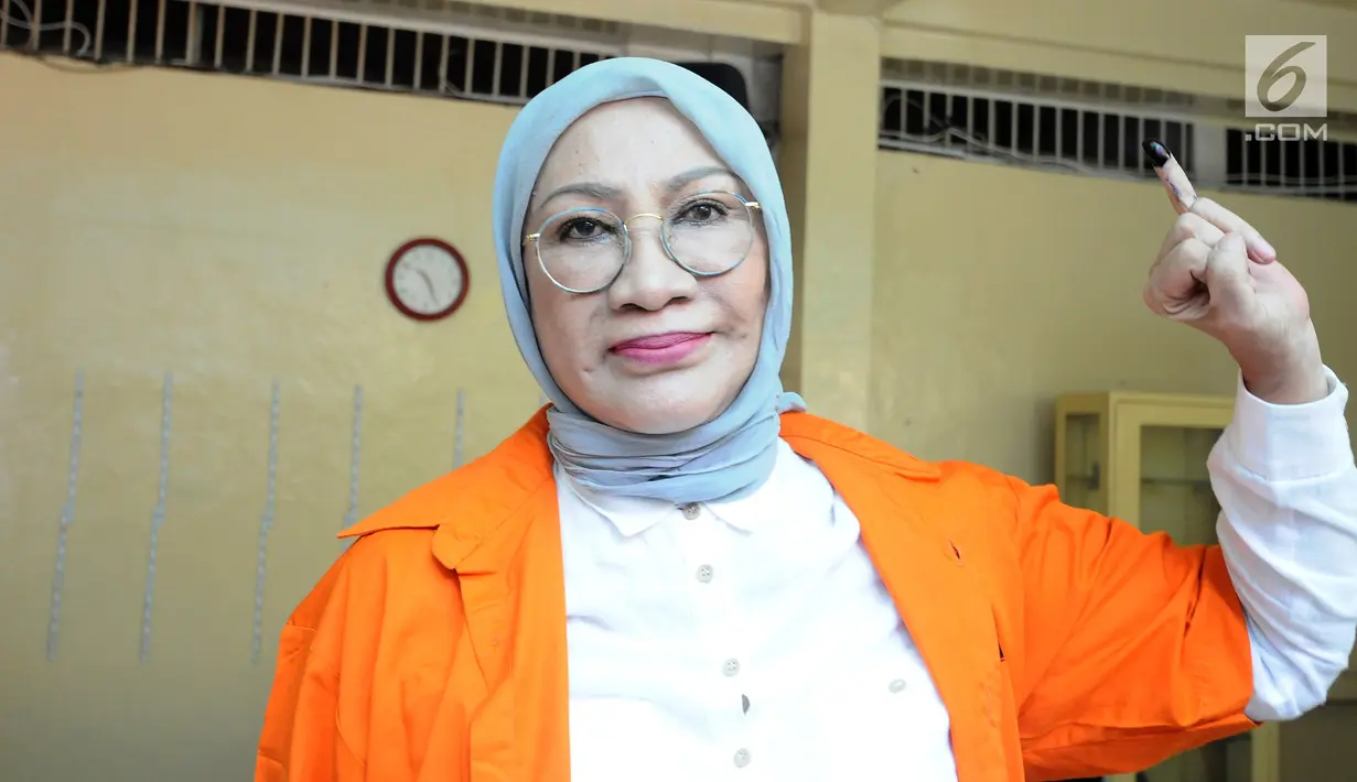 Terdakwa kasus penyebaran berita bohong atau hoaks, Ratna Sarumpaet menunjukkan jari usai mencoblos di TPS 15 rutan Polda Metro, Rabu (17/4). Ratna Sarumpaet tiba mengenakan baju tahanan berwarna oranya bersama 538 tahanan menggunakan hak suaranya pada Pemilu 2019. (Liputan6.com/Herman Zakharia)